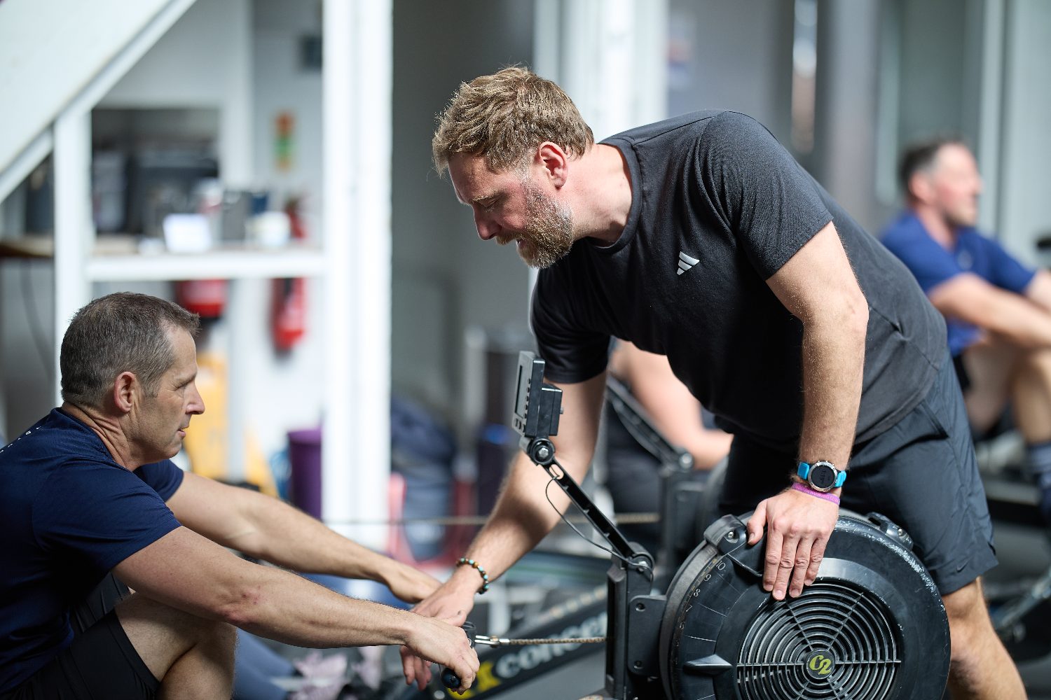 Rob Mayes guiding an athlete on the rower